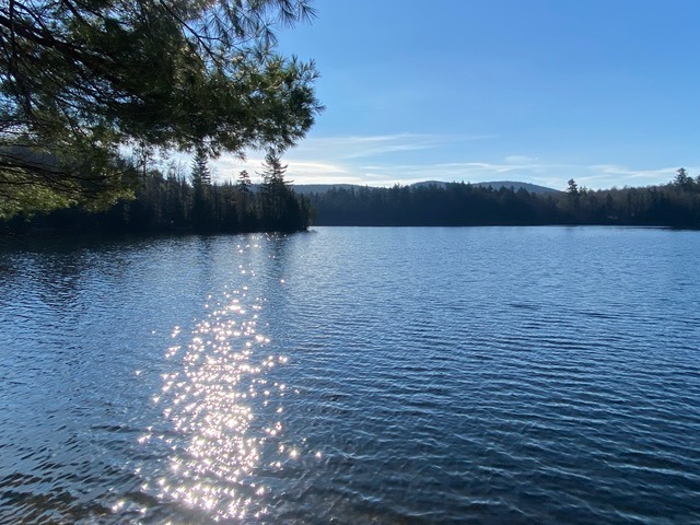 blue lake and blue sky with mountain view in the distance